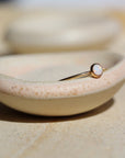 14k gold fill Opal ring placed on a ring dish in the sunlight.