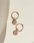 14k gold fill Starry Night Coin hoops on a white paper in the sunlight
