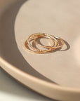 14k gold fill Tribeca Ring laid on a tan plate in the sunlight. This ring features a super cute laid look but its one ring.