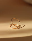 14k gold fill infinity ring laid on a tan plate.