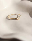 14k gold fill moonstone ring 4mm set on a white plate. This ring features a simple band with a moonstone gemstone bezeled to it.