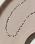 925 Sterling silver Clara Bracelet laid on a tan plate