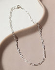 925 Sterling silver Narrow Link Anklet laid on a tan plate