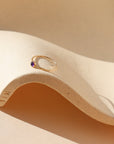 vibrant purple amethyst stone in a 14k gold fill bezel set ring on a wavy plate