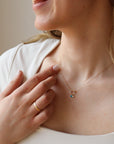 model wearing lightly hammered 14k solid gold circle pendent with dainty chain and colorful birthstone beads