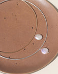 A collarbone style necklace with a pearl dangling at its center.