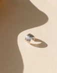 sterling silver textured ear cuff on a light background with soft shadows