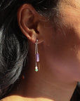 sterling silver stud earrings with chain, purple zircon tubes, pearls, and moss agate on a light background
