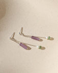 sterling silver stud earrings with chain, purple zircon tubes, pearls, and moss agate on a light background