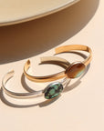 A sterling silver and 14k gold fill smooth cuff with a 13x18mm turquoise stone set at its center