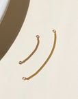 14k gold fill, curb chain offered in small and large with a 1.6 jump ring at each end of the chain. The connectors are displayed on a cream backdrop in the sunlight