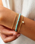 Model Wearing 14k gold fill Gigi Bracelet paired with two other bracelets