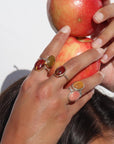 Model holding apples while wearing harvest rings