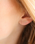 Model wearing 14k gold fill bar studs
