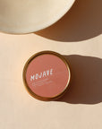 mojave scented candle in a tin displayed in the sunlight