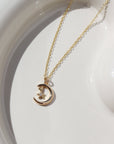 Moon Star Charm Necklace on a white plate in 14k gold filll