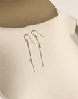 sterling silver dangle earrings on a light dish