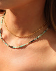 Model wearing 14k gold fill rolo styled chain stacked with a beaded gemstone necklace