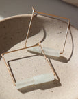 Gold Filled Square Hoops made with wire and embellished with Burma Jade Gemstones and sitting on a jewelry dish