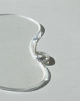 925 sterling silver ripple textured ring on a sunlit table next to a glass plate