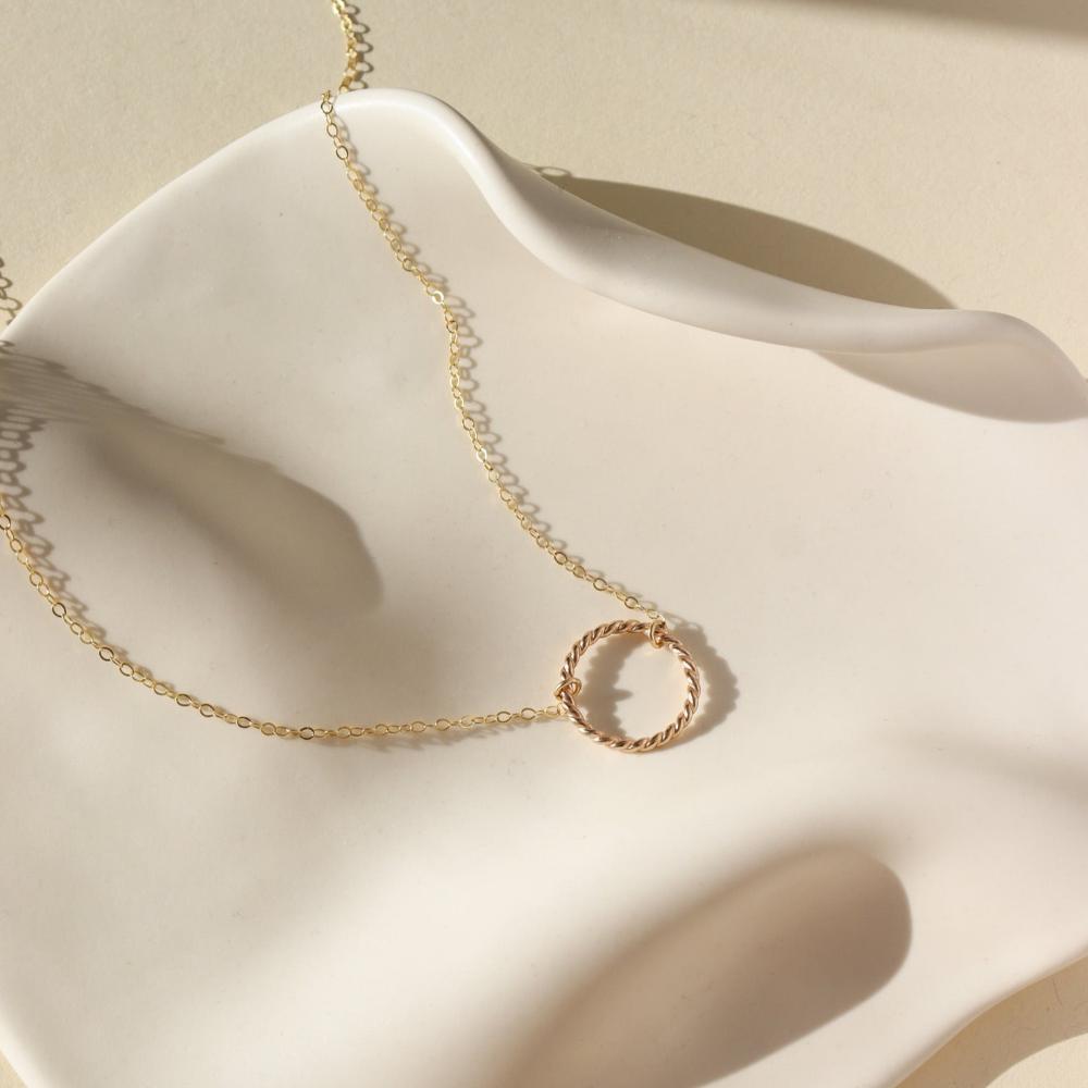 14k gold fill spiral necklace by token jewelry, photographed on a white dish