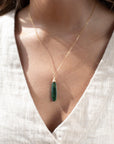 Token Jewelry standard chain necklace with a long green malachite stone, photographed on a model wearing an off white linen vest