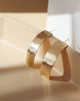 14k gold fill arc studs set on top of a gray/peach color plate. These arc studs are Handmade is Eau Claire, WI.