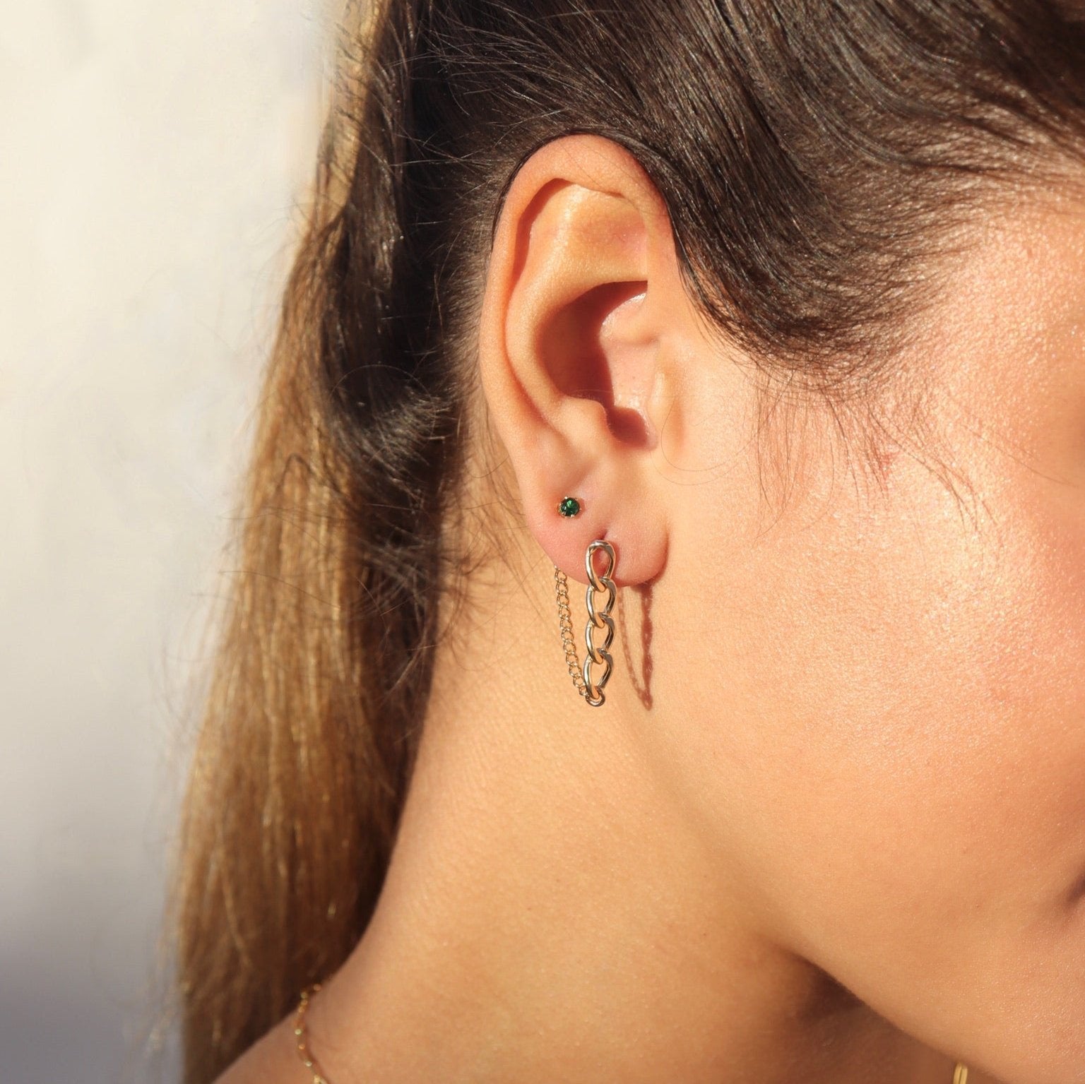 model wearing 14k gold fill chain earrings with emerald stud earrings