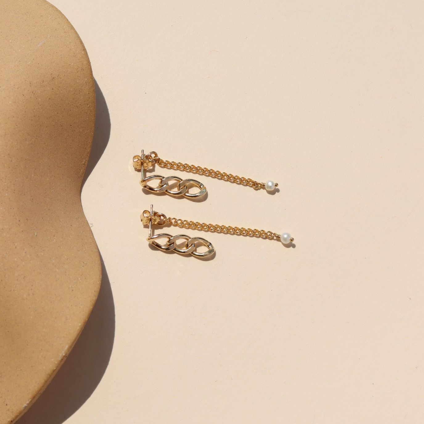 14k gold fill chain earrings with pearl accent on a light dish