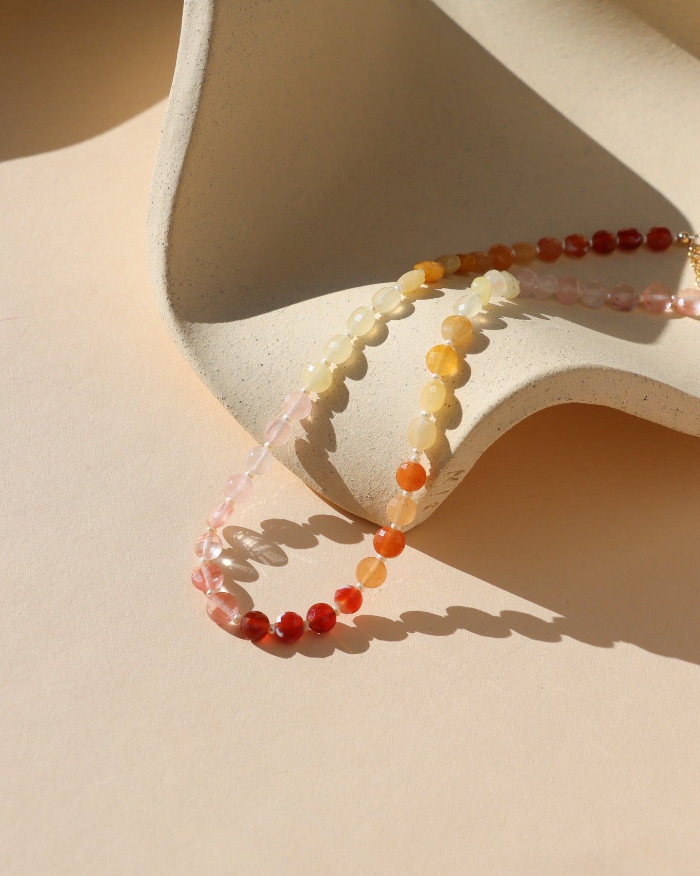 multi colored stone beads with pearls necklace displayed in the sunlight