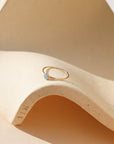14k gold fill bezel ring setting with 4mm aquamarine stone on a light dish