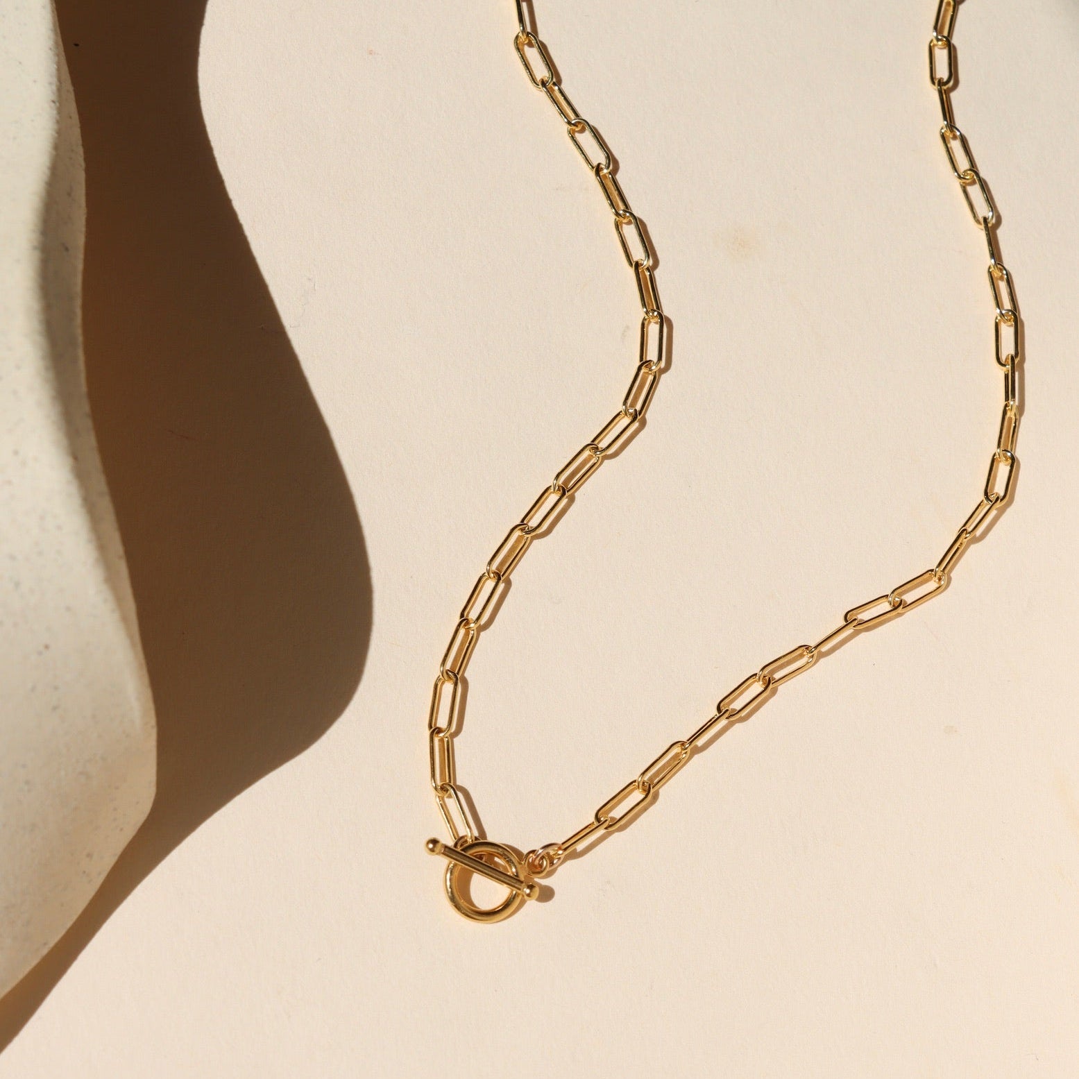  14k gold fill paperclip chain necklace with toggle clasp on a light background
