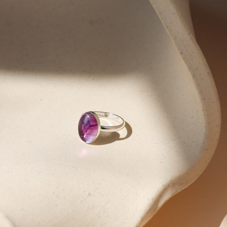 sterling silver ring setting with handset fluorite stone on a light background