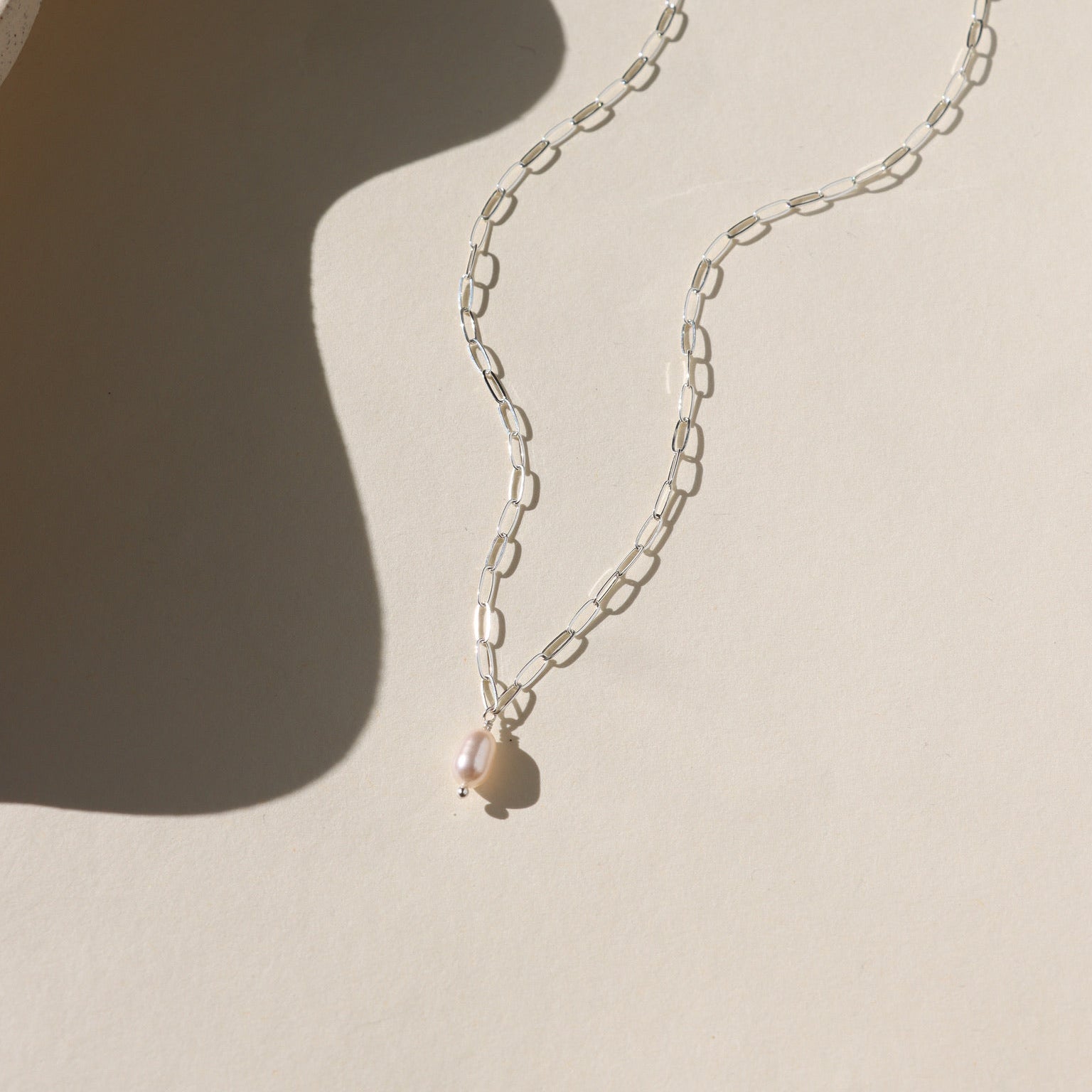 Ava Pearl Necklace with a minimalist gold chain and elegant freshwater pearl centerpiece.