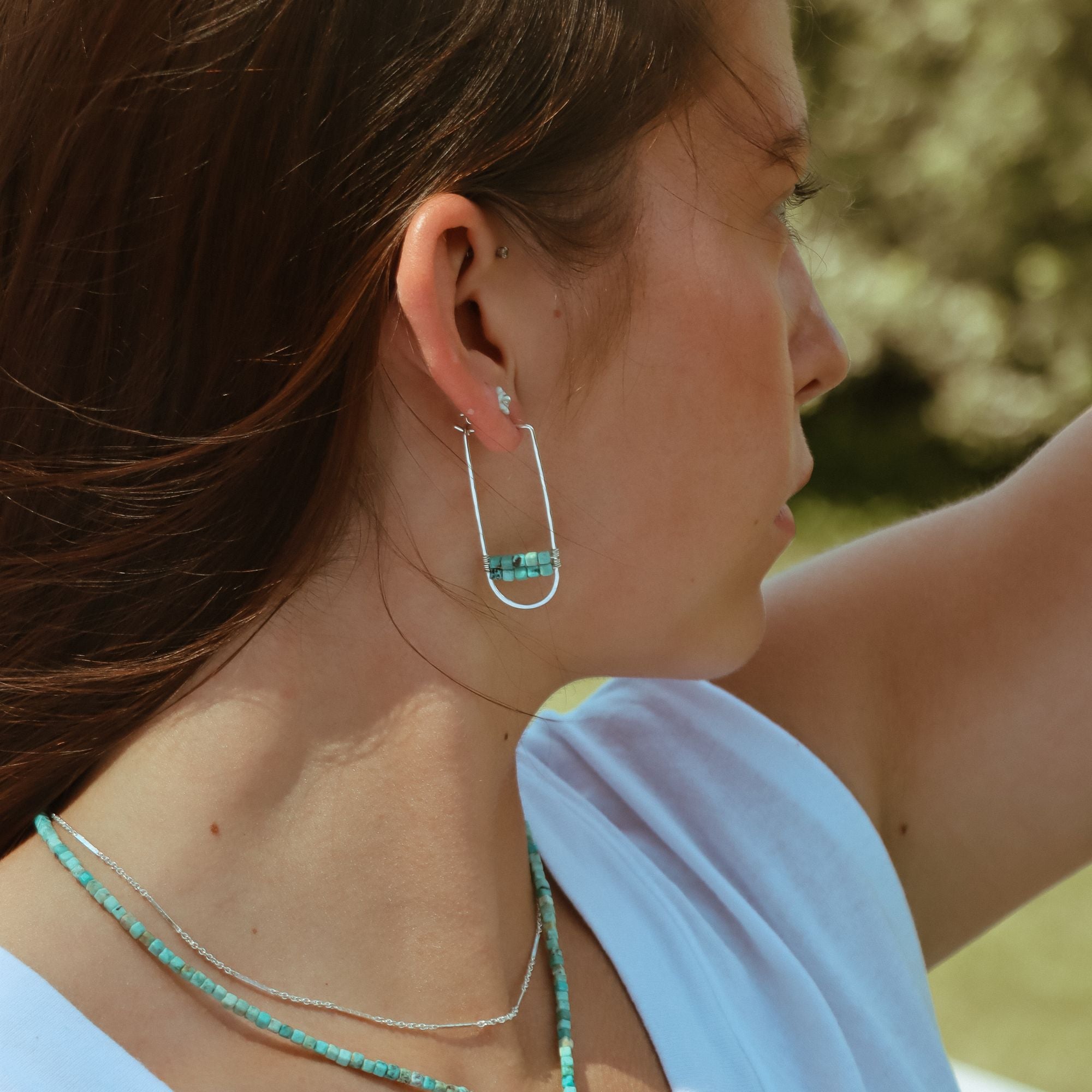 model wearing sterling silver hoops with turquoise accents