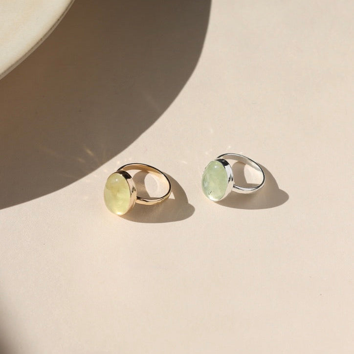 14k gold fill and sterling silver bezel rings with prehnite stones in the sunlight