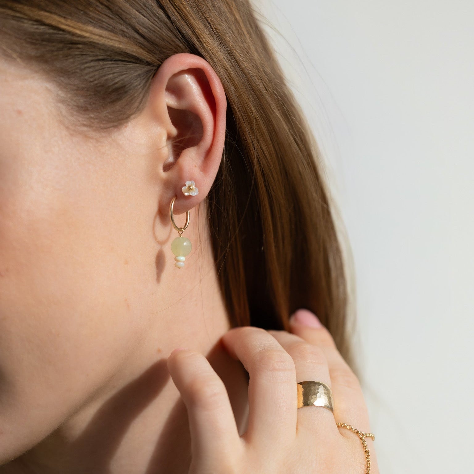 model wearing 14k gold fill hoops with opal and chalcedony gemstone charms