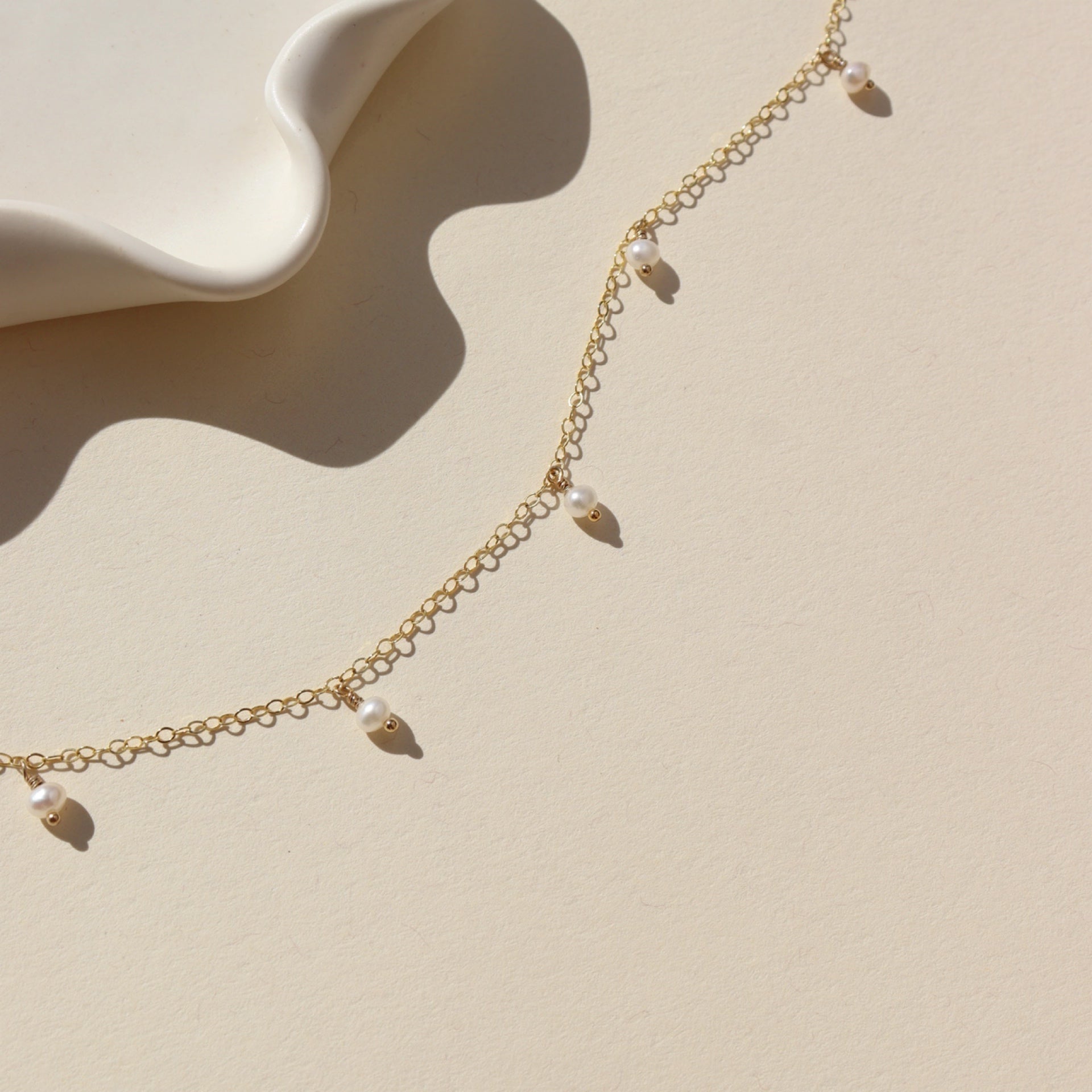 14k gold fill chain necklace with pearls on a light backgound