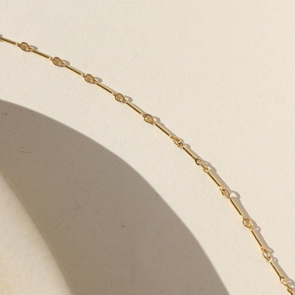 14k gold fill bar and link chain on a light background