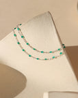 sterling silver chain with emerald enamel links on a light dish