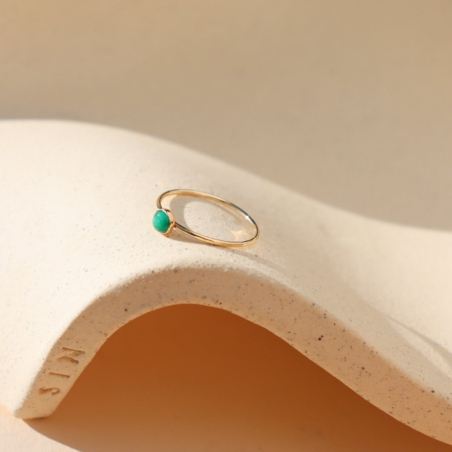 4mm emerald stone set in a 14k gold fill bezel ring setting in the sunlight
