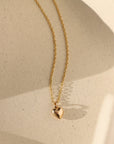 14k gold fill dainty chain with puff heart charm on a light dish