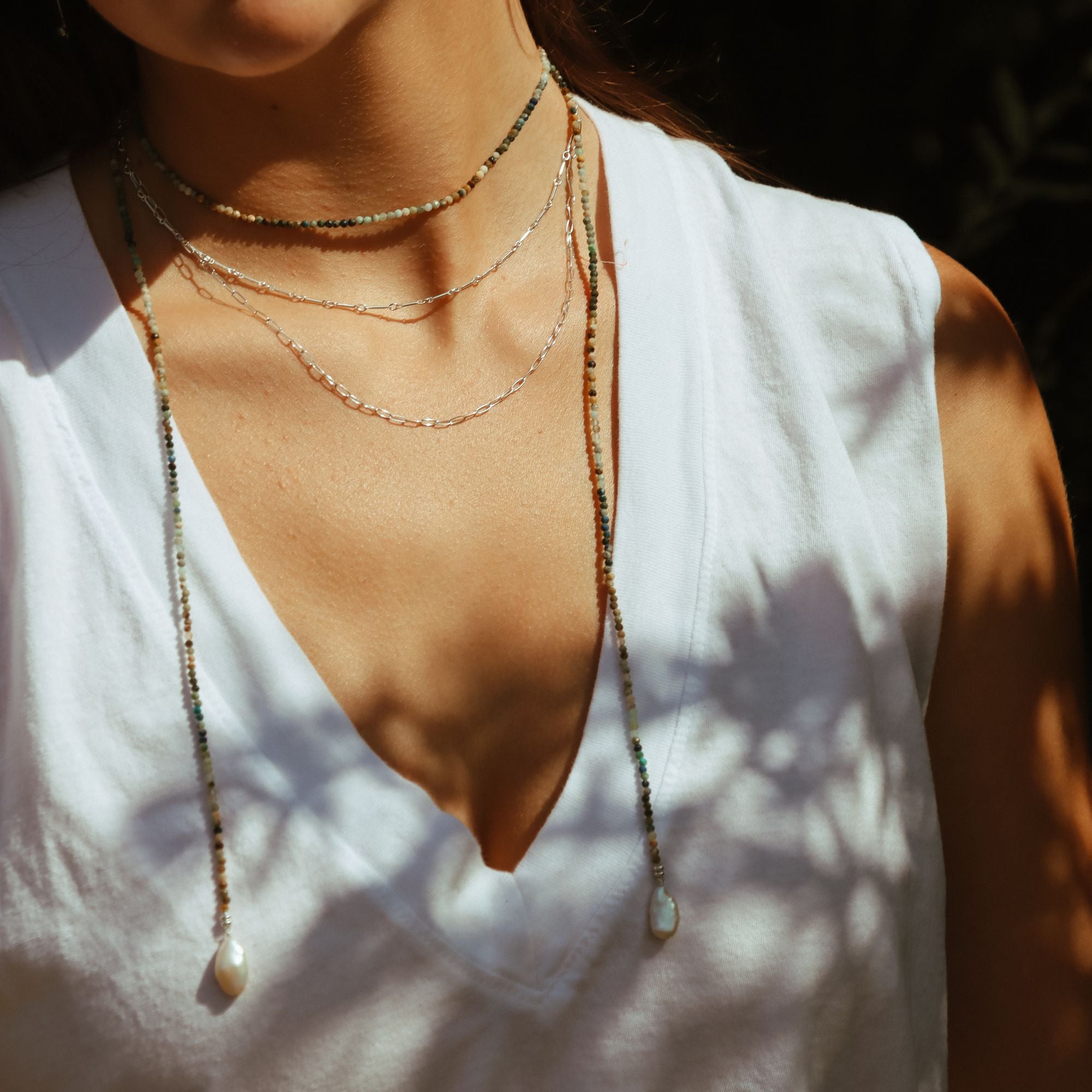 model wearing sterling silver chain necklaces with beaded wrapped necklace
