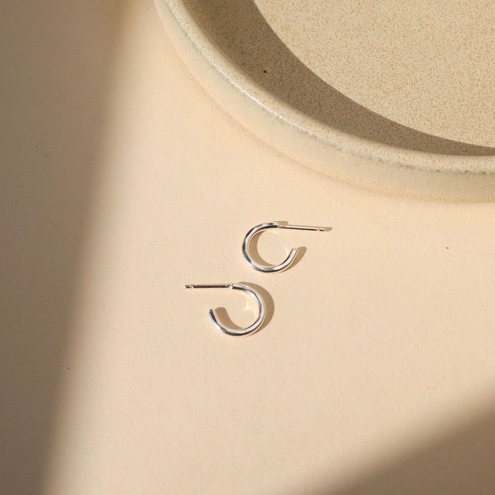sterling silver hammered hoop earrings on a light dish