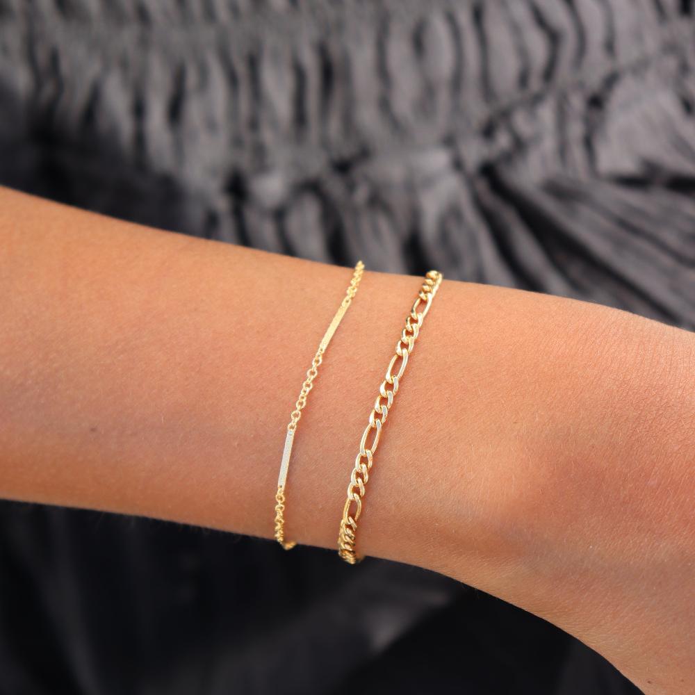 Model wearing 14k gold fill figaro chain bracelet with bar & cable chain bracelet in 14k gold fill