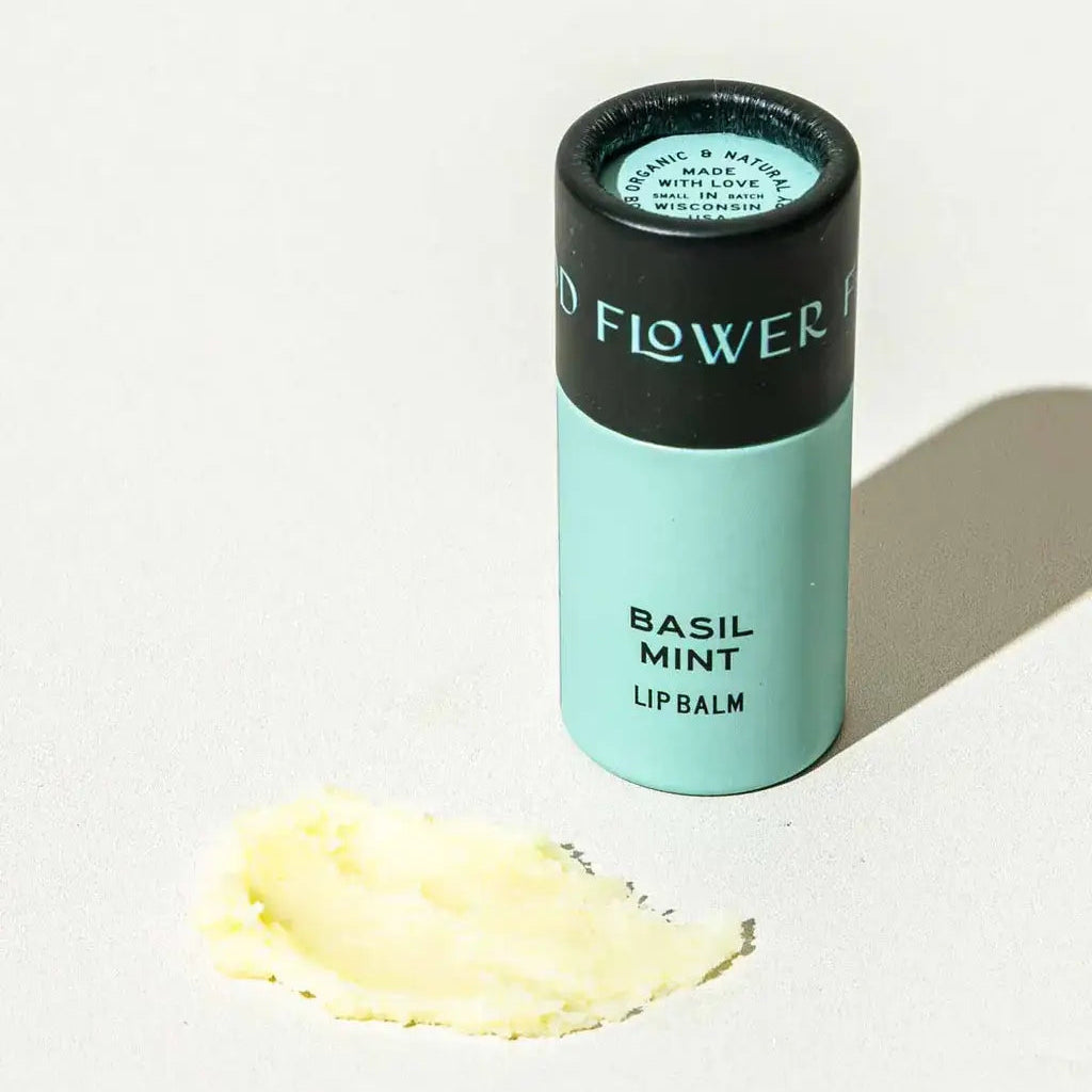 Lip balm container labeled 'Basil Mint' on a light background