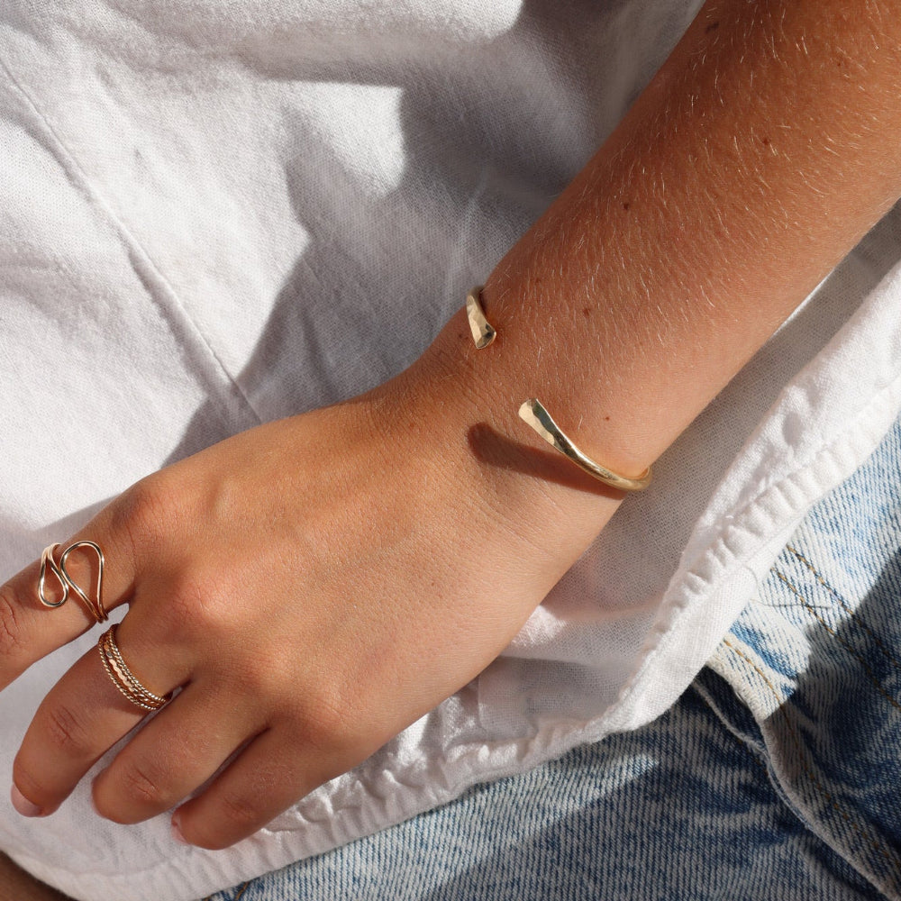model wearing 14k gold fill hammered cuff bracelet with 14k gold fill rings 