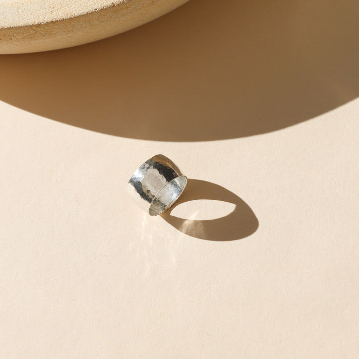 sterling silver textured thick band ring on a light background