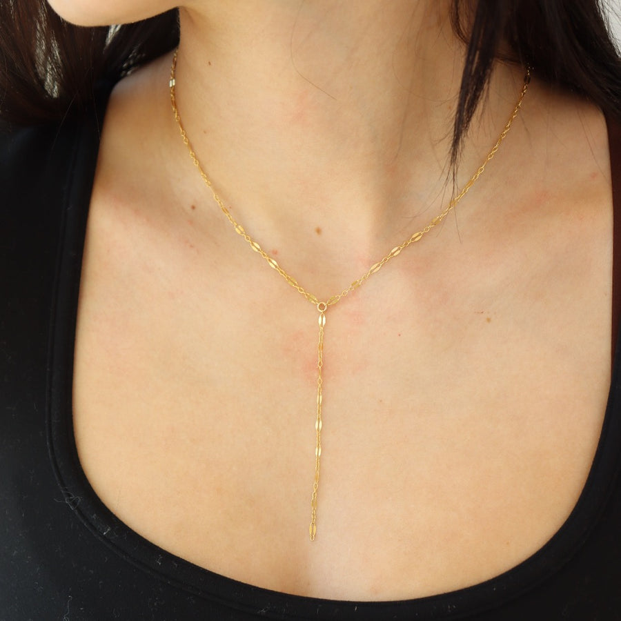 14k gold fill lariat chain, photographed on a brunette model wearing a black t shirt
