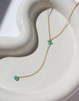 14k gold fill Green Opal Lariat Necklace laid on a white jewelry plate in the sunlight. This necklace features our simple chain connected by the Green opal gemstone dangling on the lariat is another green opal lariat.